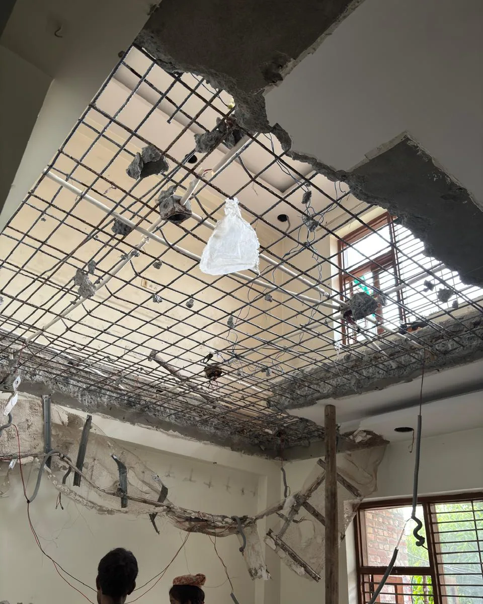 The same room during works: the false ceiling stripped out and the slab above cut open, its steel reinforcement exposed.